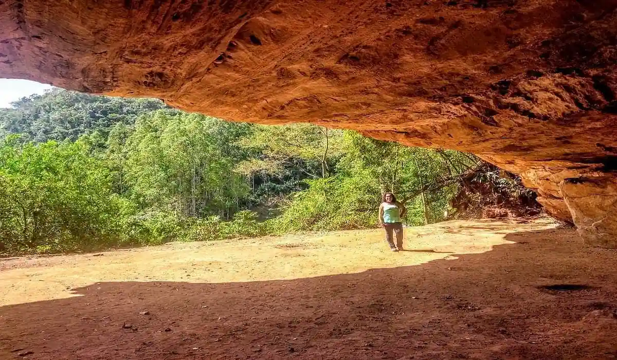 Entrada imponente da Gruta do Limoeiro em Castelo, Espírito Santo, com paredão de pedra e vegetação.