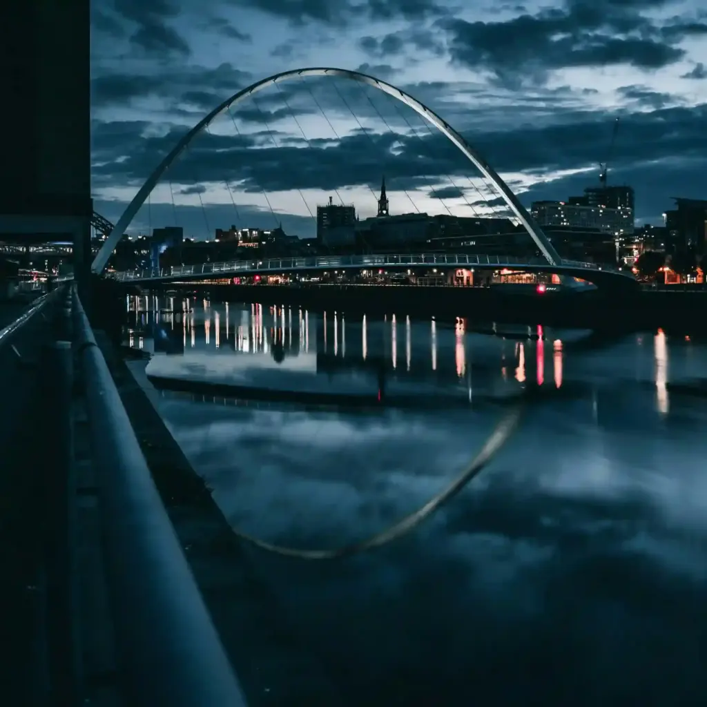 Newcastle-upon-Tyne: Uma Jornada pela História e Hospitalidade Geordie 2 Vista panorâmica das pontes iluminadas sobre o Rio Tyne em Newcastle, Inglaterra, ao anoitecer.