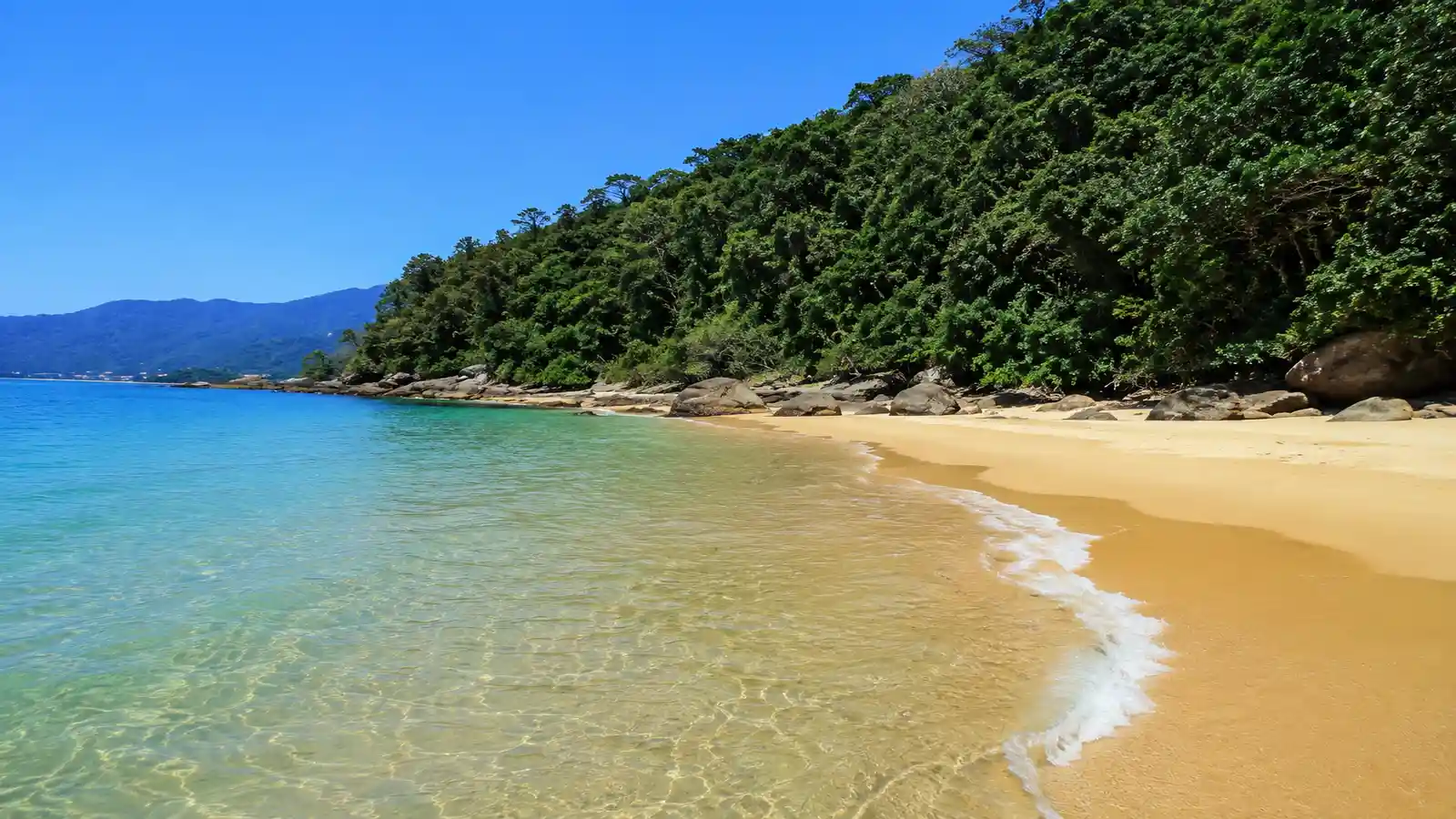 Praia do Iporanga no Guarujá com cachoeira mar calmo e Mata Atlântica