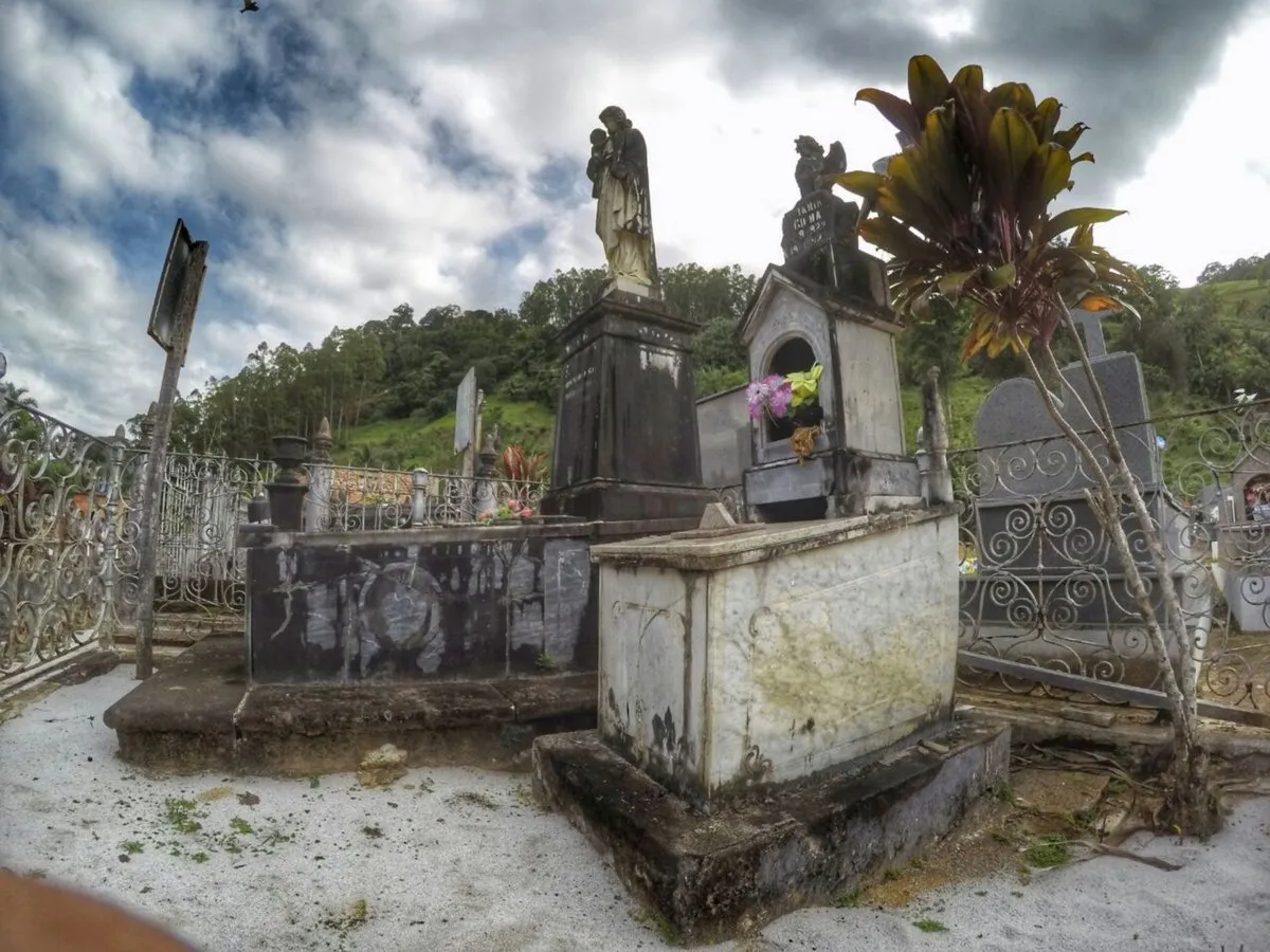 Foto do túmulo de Maria Gilda no cemitério de Santa Leopoldina, com água visível na superfície da sepultura de concreto.