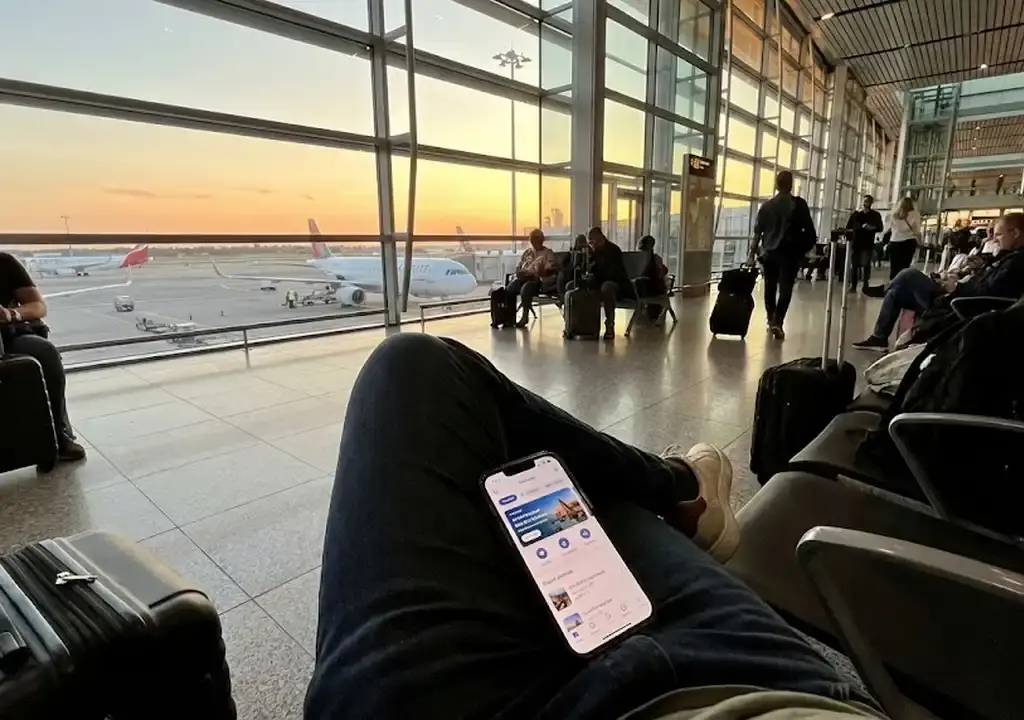Viajante usando aplicativo de celular para buscar passagens aéreas baratas em um aeroporto.
encontrar passagens aéreas baratas