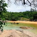 Família brincando na beira do mar calmo em uma praia do Espírito Santo, ideal para crianças. praias seguras para crianças no Espírito Santo