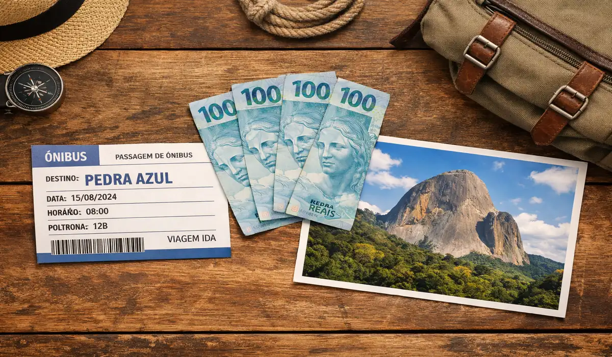 Composição fotográfica sobre uma mesa de madeira contendo uma passagem de ônibus para Pedra Azul, três notas de 100 reais brasileiras e uma foto da Pedra do Lagarto. Representação visual de um roteiro de viagem econômico nas montanhas capixabas.